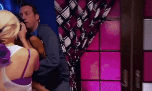 a man and woman are having sex in a room with pink lights
