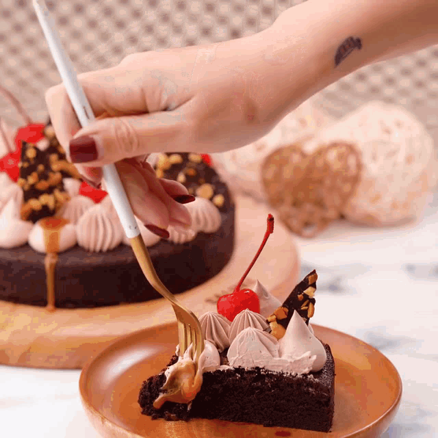 a person with a tattoo on their wrist holds a fork over a piece of chocolate cake