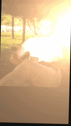 a blurred image of a person in a park with trees in the background