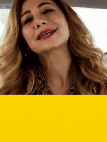 a woman in a leopard print shirt is smiling