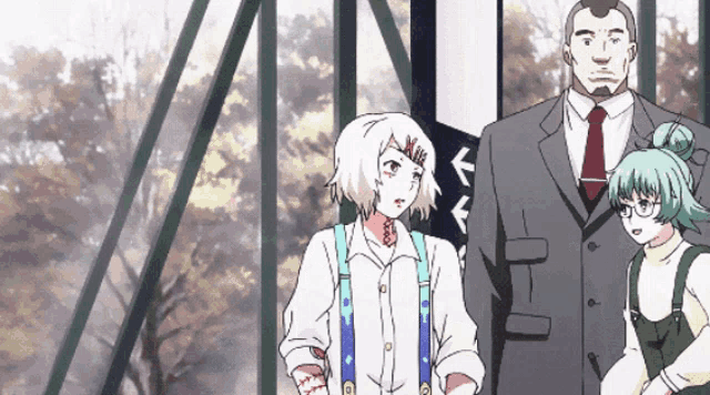 a man in a suit and tie stands between two girls