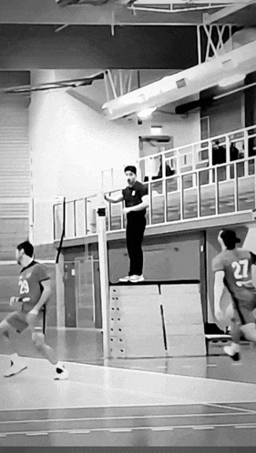 a man with the number 27 on his jersey stands on a volleyball net