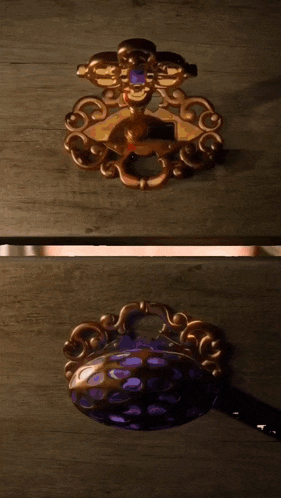 a gold key with a purple stone sits on top of a wooden box