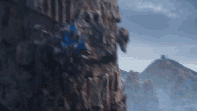 a blurred image of a mountain with a blue sky in the background