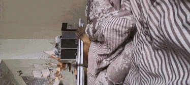 a person is laying in bed with a striped comforter