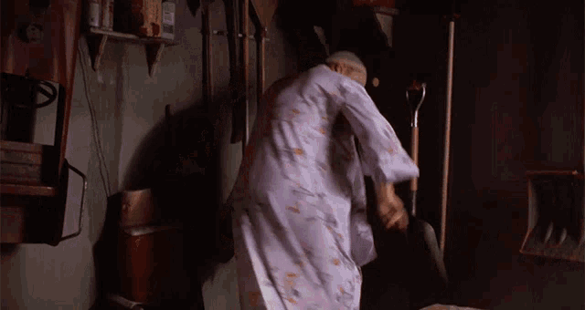 a woman in a purple robe is standing in a room with a shovel