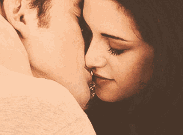 a woman is kissing a man on the cheek