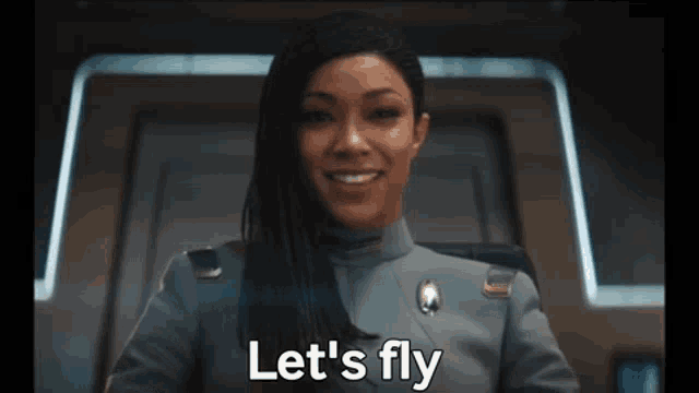 a woman in a military uniform is smiling and saying let 's fly .