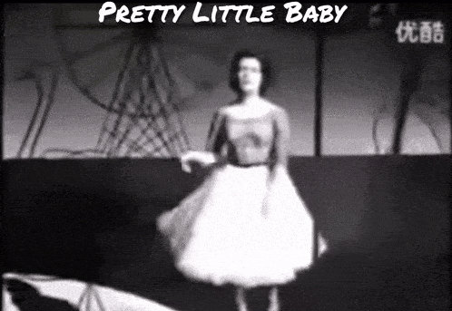 a woman in a white dress is dancing in front of a ferris wheel and the words " pretty little baby " above her