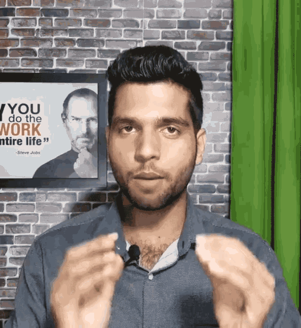 a man in front of a framed picture of steve jobs