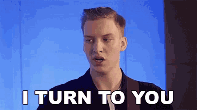 a young man is saying `` i turn to you '' while standing in front of a blue wall .