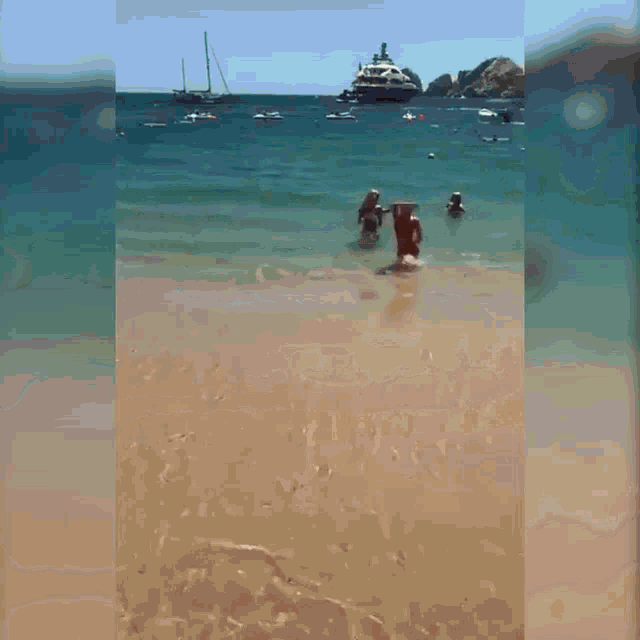 a woman in a red bathing suit is walking out of the ocean