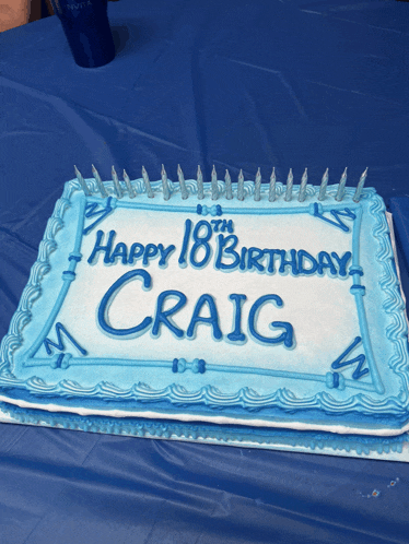 a blue and white birthday cake with the name craig on it