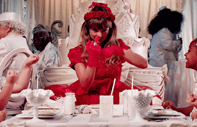 a woman in a red dress sitting at a table