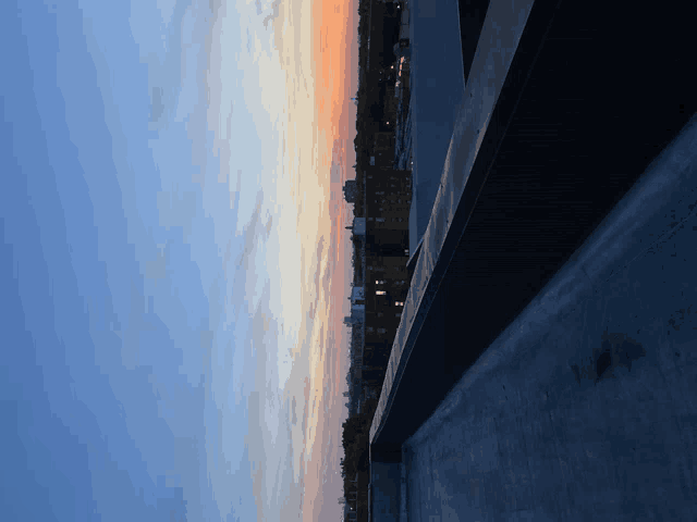a view of a city skyline at sunset from a rooftop
