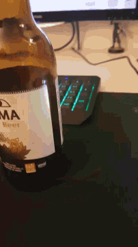 a bottle of magma beer sits on a table next to a computer keyboard