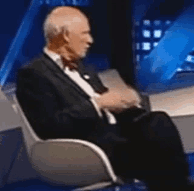 a man in a suit is sitting in a chair