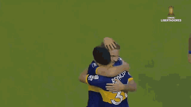 two soccer players are hugging and one has the number 31 on his shirt