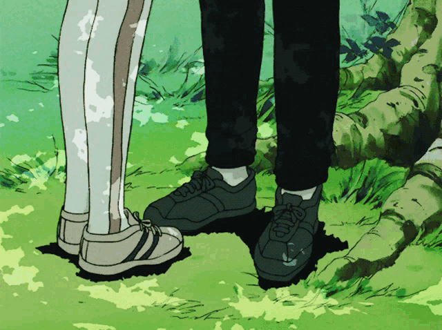 a couple of people standing next to each other with their feet in the grass