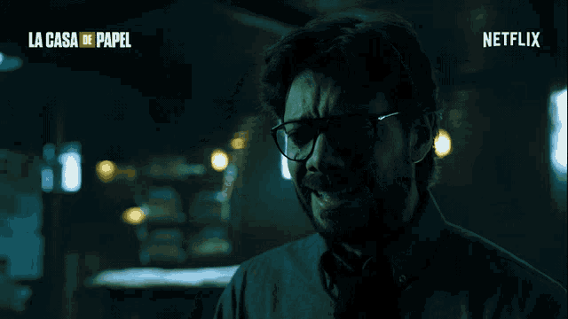 a man wearing glasses is in a dark room with the words la casa de papel on the bottom right