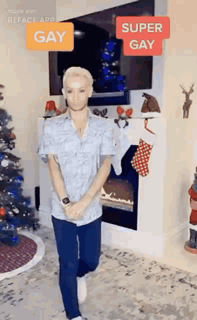 a man is standing in front of a christmas tree and fireplace .