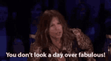 a woman is sitting in front of a microphone and says `` you don t look a day over fabulous ! ''