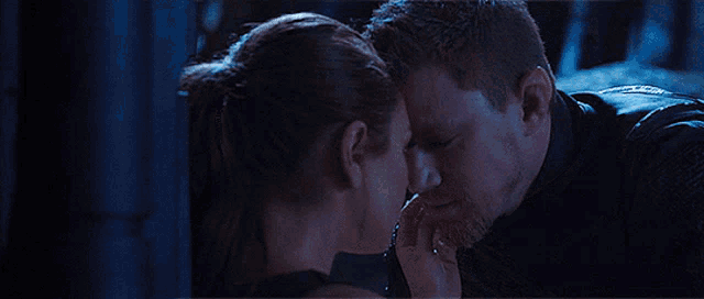 a man and a woman are touching each other 's faces