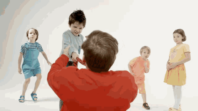 a man in a red sweater is holding a child 's arm