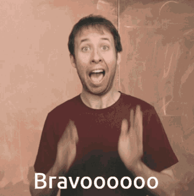 a man in a red shirt is making a surprised face in front of a sign that says bravoooo