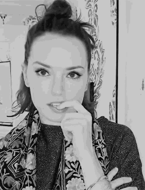 a black and white photo of a woman with her hand to her mouth