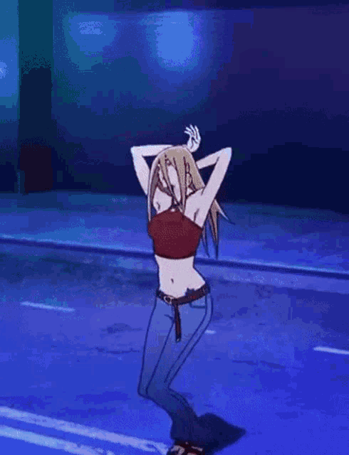 a woman in a crop top and jeans is dancing on a ledge .