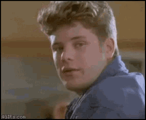 a woman wearing sunglasses and a blue shirt is smiling in a 4gifs.com gif