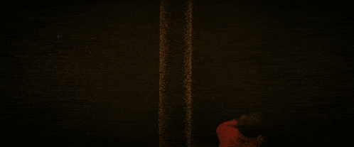 a man is laying on the ground in the middle of a dark street