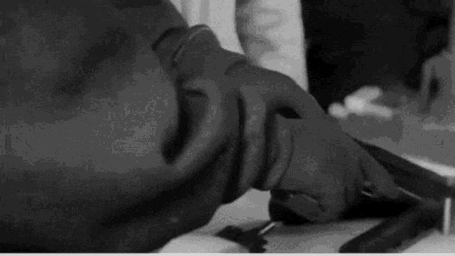 a black and white photo of a person wearing gloves holding a knife .