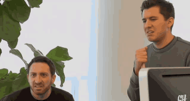 two men are standing in front of a computer monitor that says clif