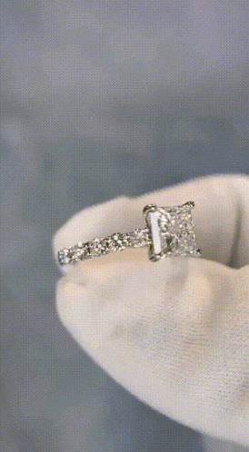 a close up of a diamond ring on a white cloth