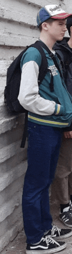 a boy wearing a baseball cap and a jacket with the word eagles on the front