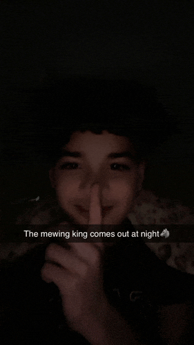 a young boy is making a snapchat with the caption the mewing king comes out at night