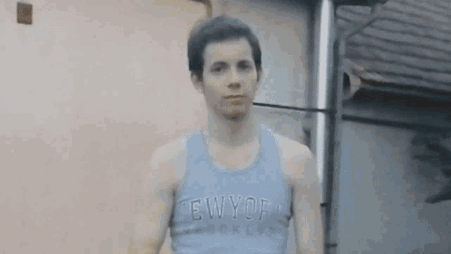 a young man wearing a blue tank top that says new york on it