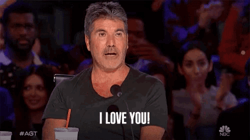 a man sitting in front of a microphone says " i love you "