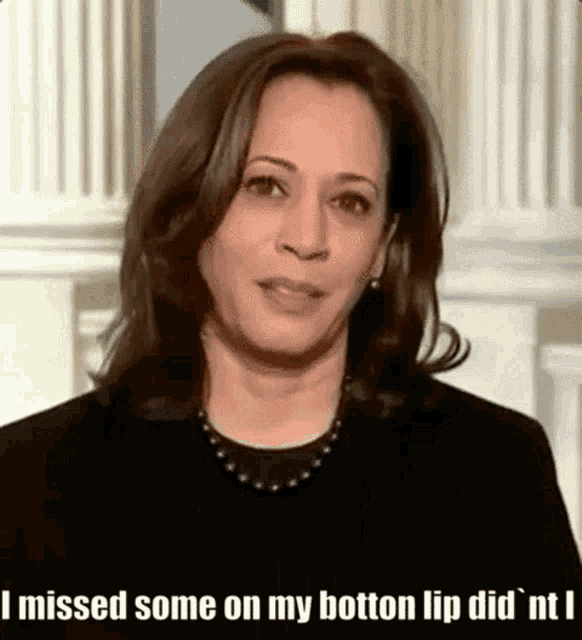 a woman is wearing a black shirt and a pearl necklace .