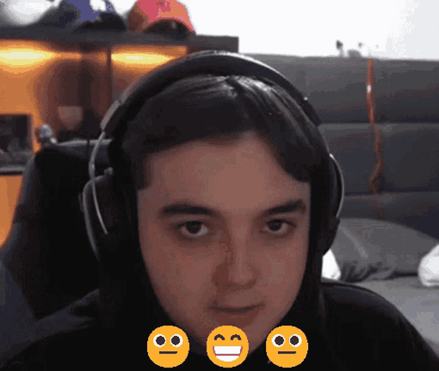 a young man wearing headphones with smiley faces on his face