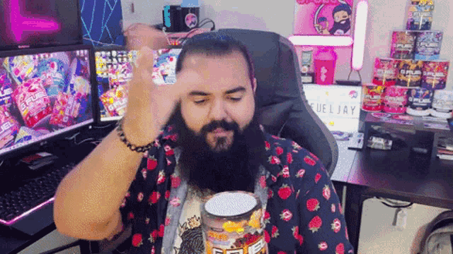 a man with a beard is sitting at a desk with a laptop that says fueljay