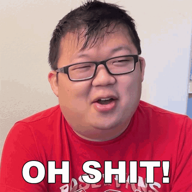 a man wearing glasses and a red shirt is saying " oh shit "
