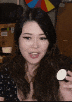 a woman holding a small white object in her hand