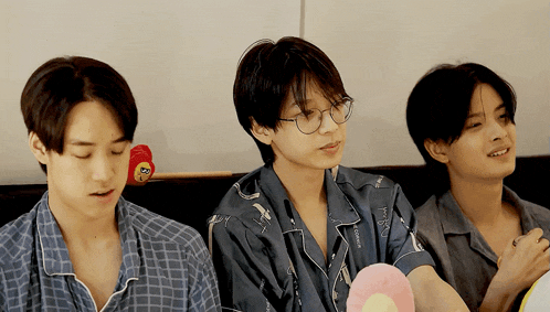 three young men are sitting next to each other and one of them has a stuffed animal on his head that says ' a '
