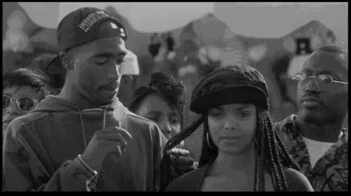 a black and white photo of a man and a woman in a crowd .