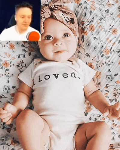 a baby wearing a shirt that says loved is laying on a bed