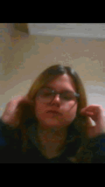 a blurry picture of a girl wearing glasses and a black shirt