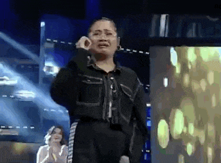 a woman is crying while standing on a stage .